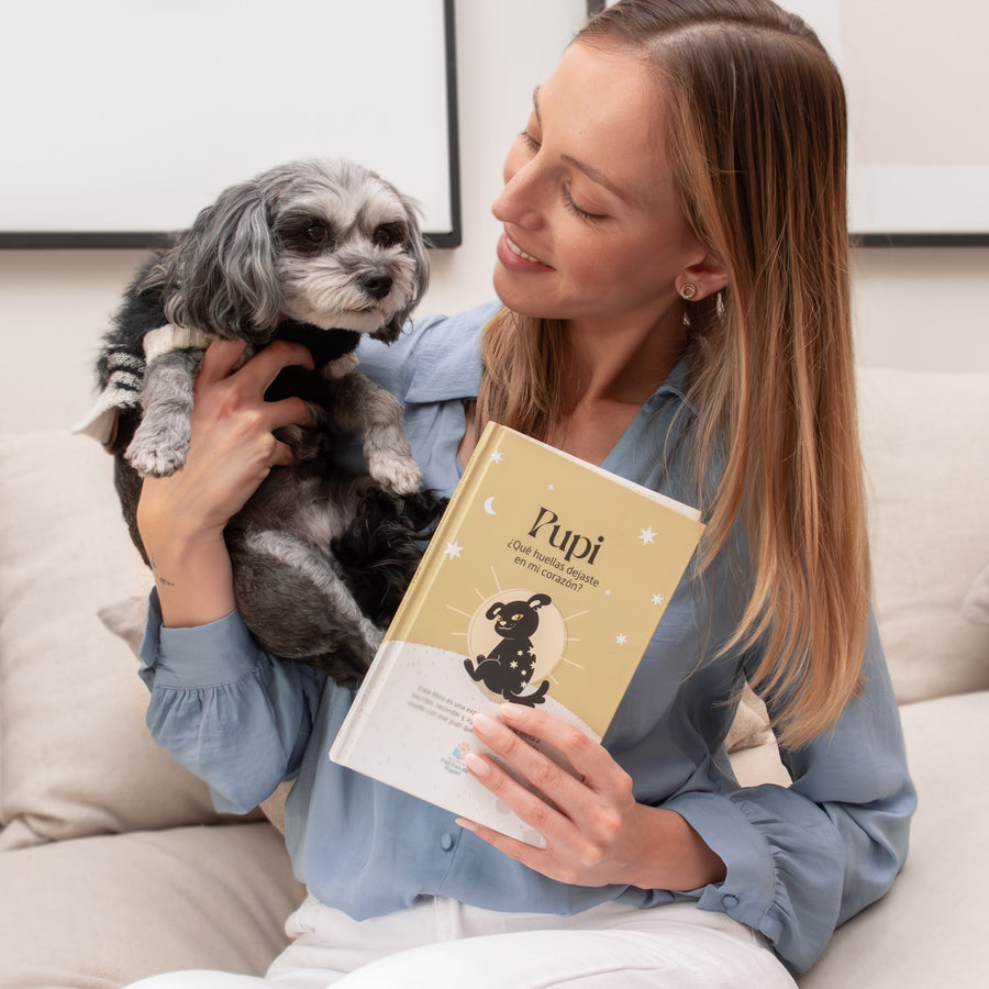 Persona con su perro sosteniendo el libro Pupi de Editorial Patitas de Papel
